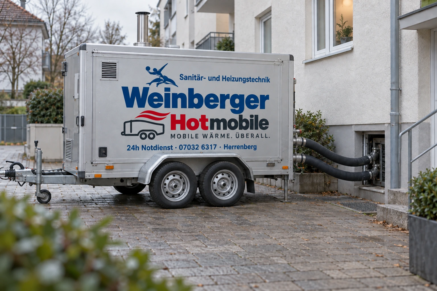 Weinberger-Heizmobil mit Heizschläuchen am Kelleranschluss eines Wohnhauses